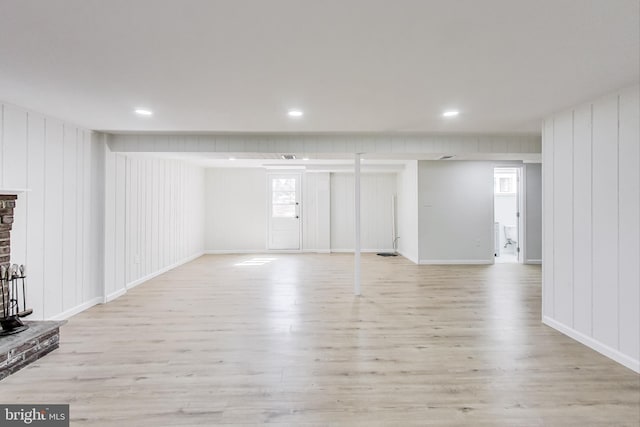 unfurnished living room with recessed lighting, light wood-type flooring, and baseboards