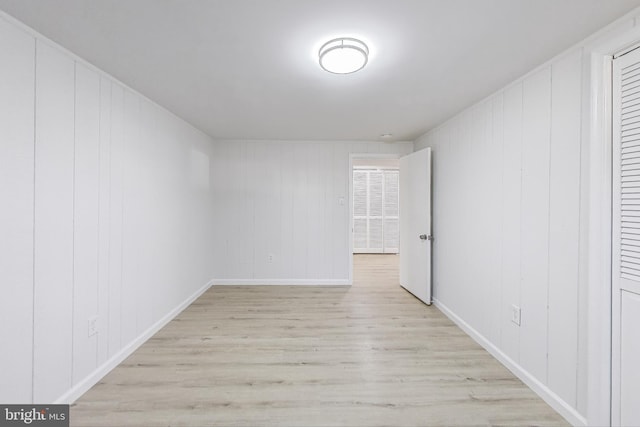 empty room featuring baseboards and light wood finished floors