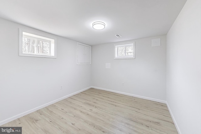 basement with light wood finished floors, visible vents, and baseboards