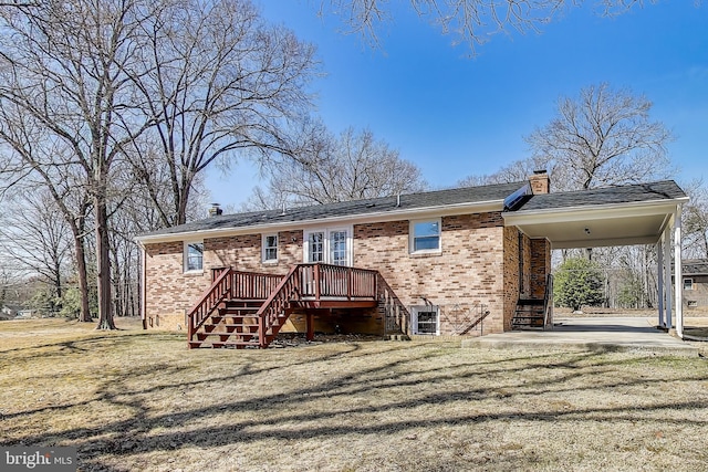 rear view of house featuring an attached carport, brick siding, a chimney, and a lawn