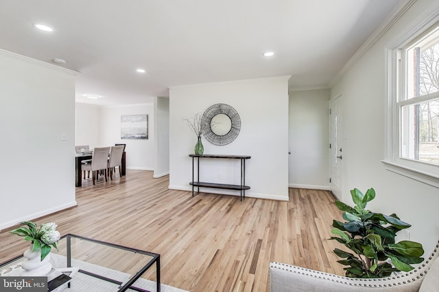 sitting room featuring baseboards, wood finished floors, and ornamental molding