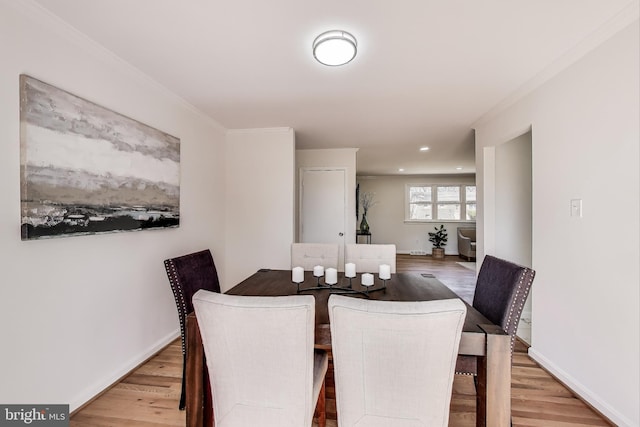 dining area featuring crown molding, baseboards, and wood finished floors