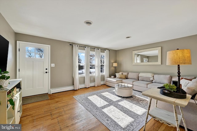 living room with a healthy amount of sunlight and light hardwood / wood-style flooring