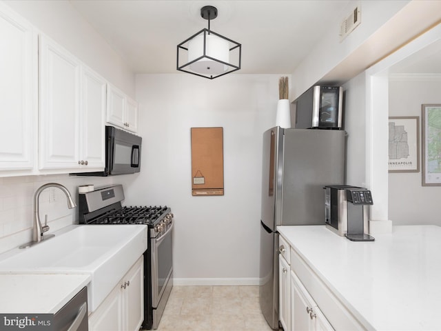 kitchen with hanging light fixtures, appliances with stainless steel finishes, sink, and white cabinets