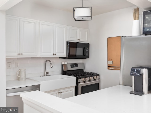 kitchen with pendant lighting, sink, appliances with stainless steel finishes, backsplash, and white cabinets