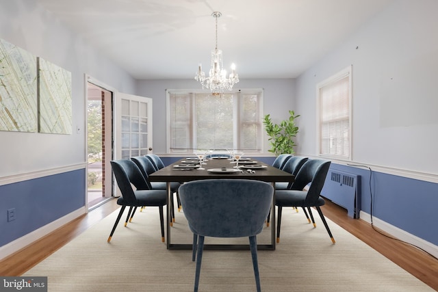 dining room with a wealth of natural light, a chandelier, radiator heating unit, and light hardwood / wood-style floors