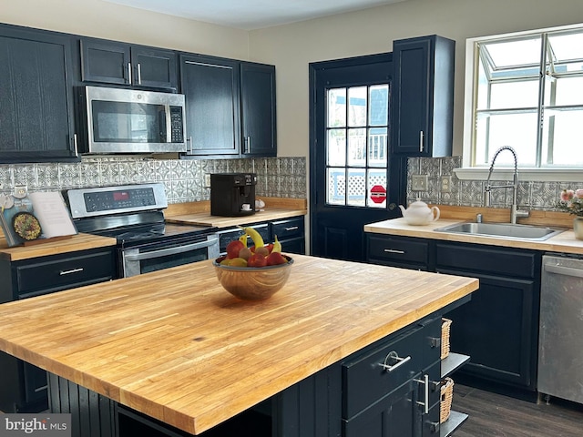 kitchen with sink, backsplash, plenty of natural light, and appliances with stainless steel finishes