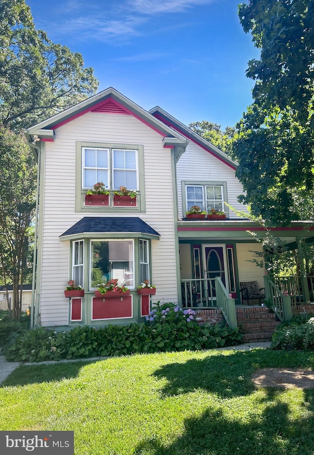 view of front of property featuring a front yard and covered porch