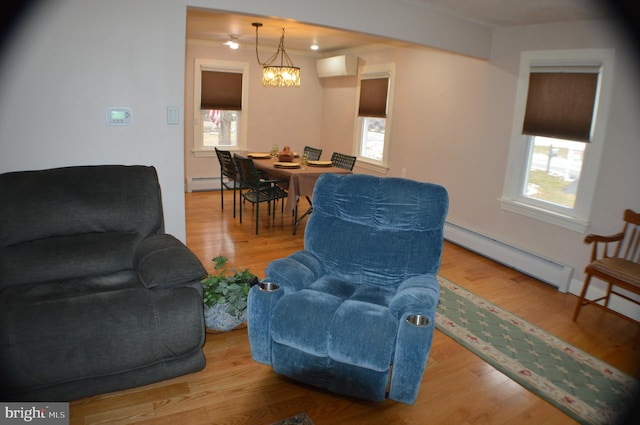 living room with a baseboard radiator, light hardwood / wood-style floors, and a chandelier