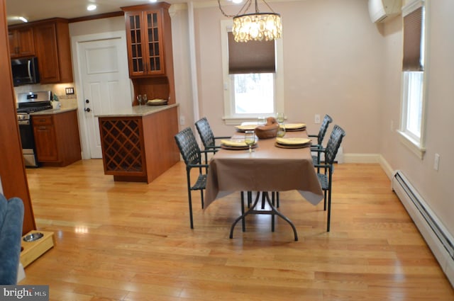 dining space with an inviting chandelier, a wall mounted air conditioner, light hardwood / wood-style flooring, and baseboard heating