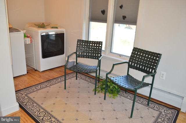 living area with independent washer and dryer and light wood-type flooring