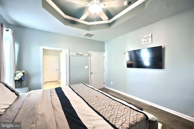 bedroom featuring ceiling fan, a raised ceiling, and hardwood / wood-style floors