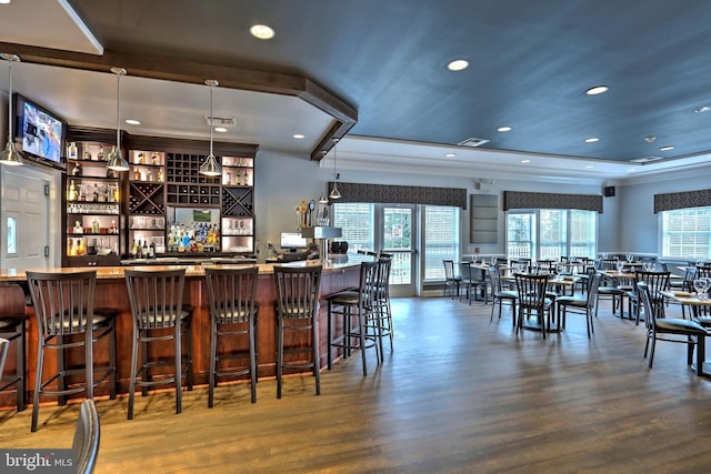 bar with dark hardwood / wood-style flooring and hanging light fixtures