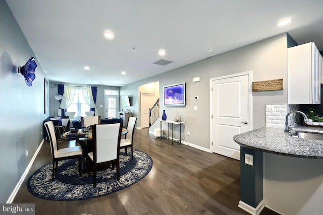 dining room with sink and dark hardwood / wood-style flooring