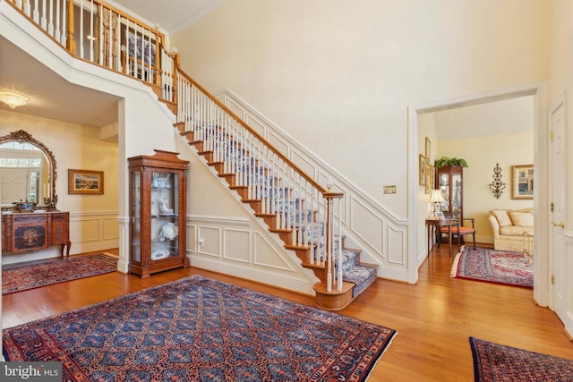 stairs with a high ceiling and wood-type flooring