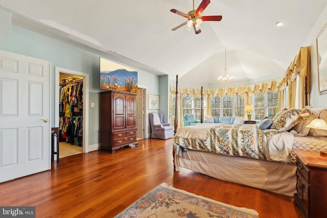 bedroom featuring wood-type flooring, a spacious closet, vaulted ceiling, a closet, and a notable chandelier