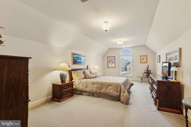 bedroom featuring vaulted ceiling and light carpet