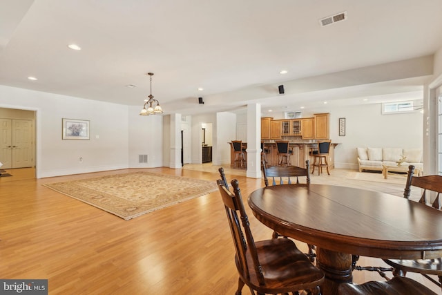 dining area featuring an inviting chandelier and light wood-type flooring