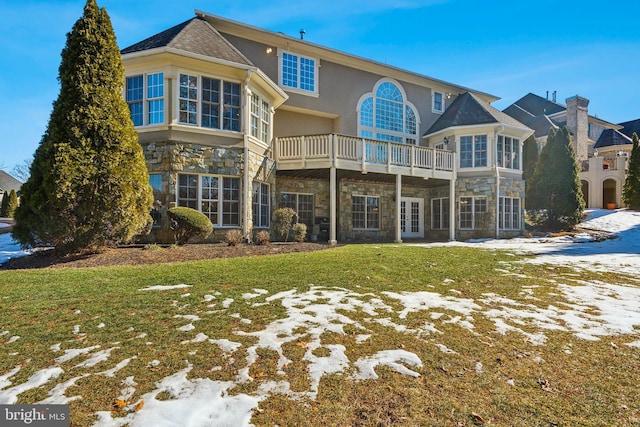 snow covered house featuring a lawn