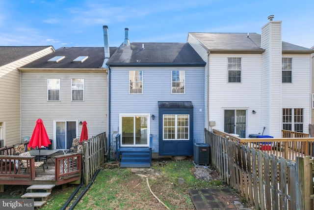 back of house with cooling unit and a deck