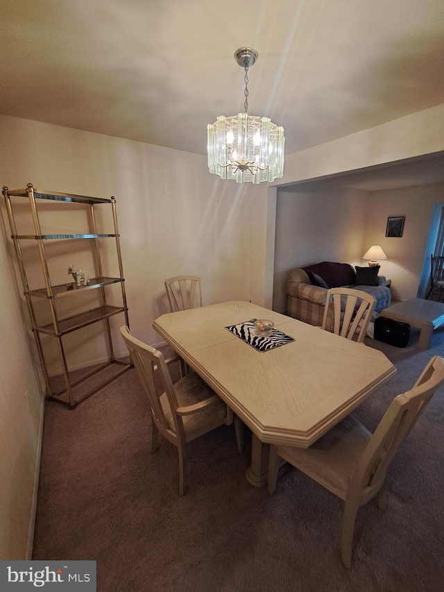 dining space with carpet flooring and a chandelier