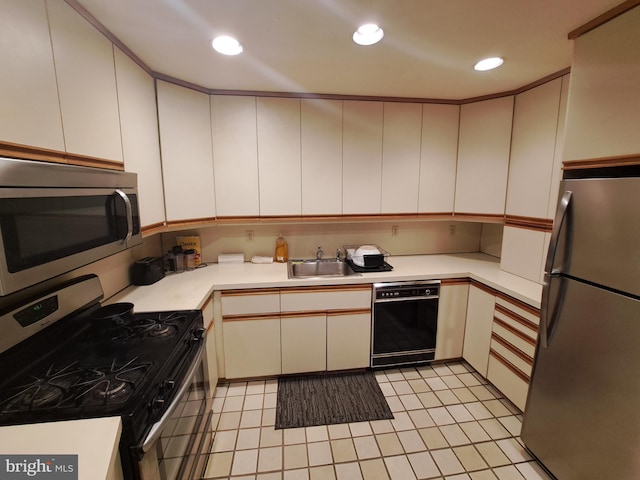 kitchen with sink, light tile patterned floors, and appliances with stainless steel finishes