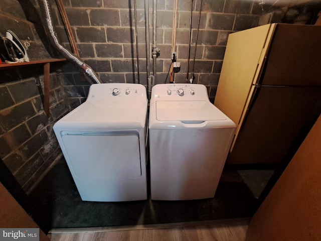 laundry room featuring hardwood / wood-style flooring and washing machine and clothes dryer