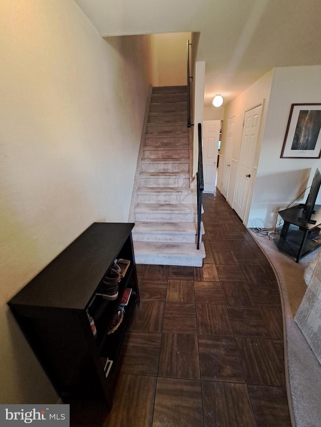 stairs featuring parquet flooring