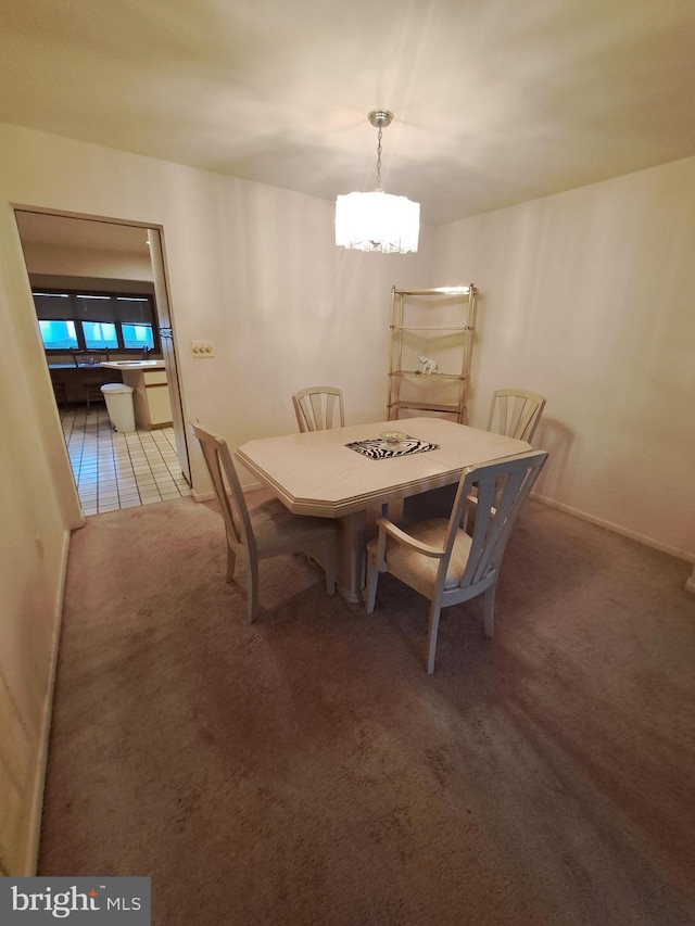 dining room featuring carpet and an inviting chandelier