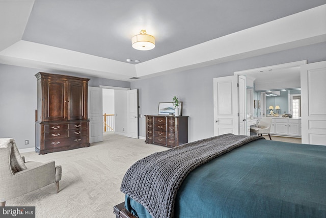 carpeted bedroom with a raised ceiling