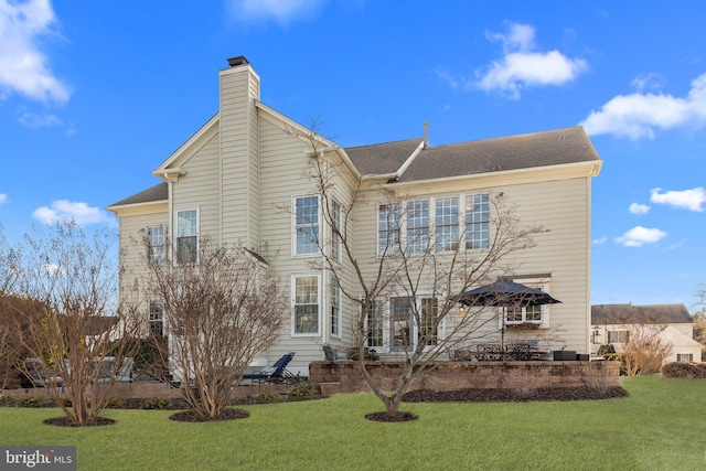 rear view of property featuring a lawn