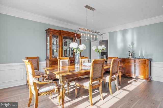 dining space featuring hardwood / wood-style flooring and ornamental molding