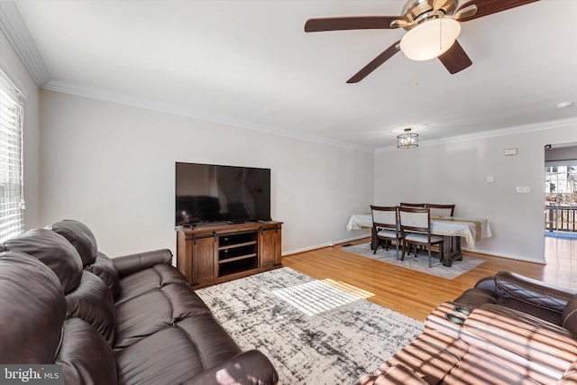 living room with hardwood / wood-style flooring, ceiling fan, and ornamental molding