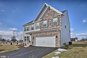 view of front of home featuring driveway, a front lawn, and an attached garage