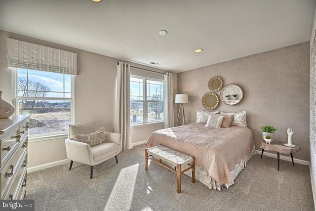 bedroom with multiple windows, light colored carpet, and baseboards