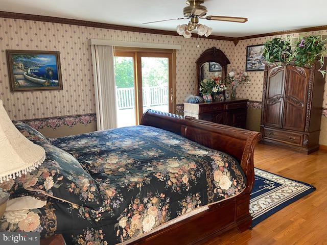 bedroom with access to exterior, crown molding, wood-type flooring, and ceiling fan