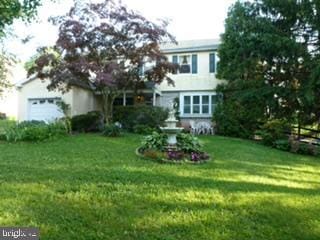 view of front facade with a garage and a front lawn