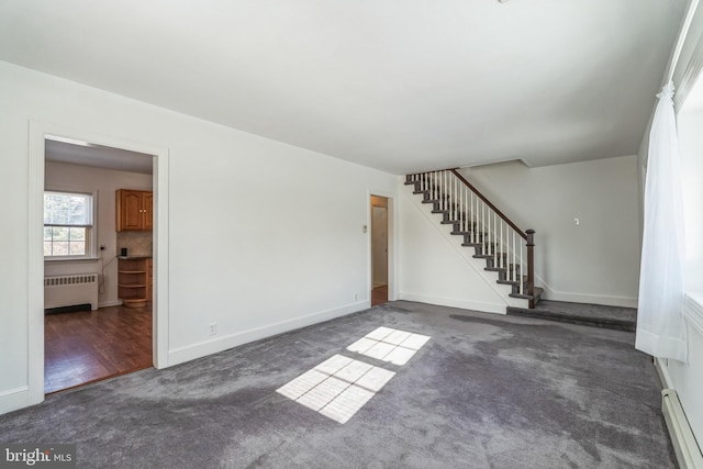 unfurnished living room featuring radiator, dark carpet, and a baseboard heating unit