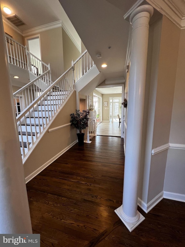 foyer with ornate columns, crown molding, and dark hardwood / wood-style floors