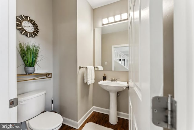 bathroom featuring wood-type flooring and toilet