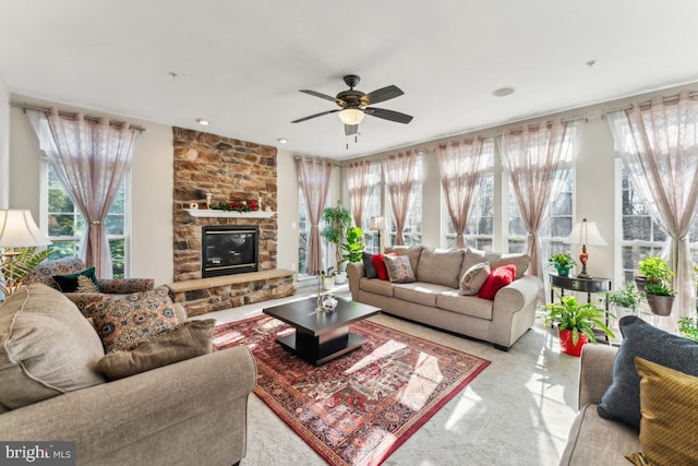 living room featuring ceiling fan and a fireplace