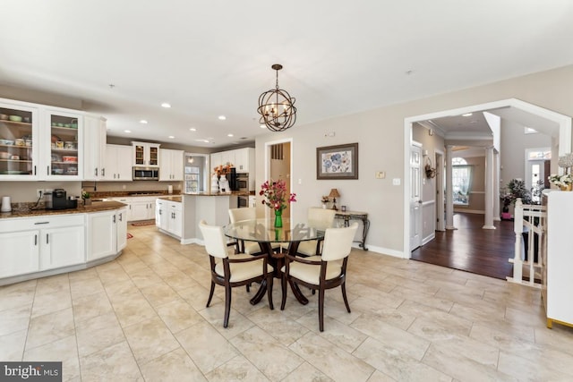 dining space with ornate columns and a notable chandelier