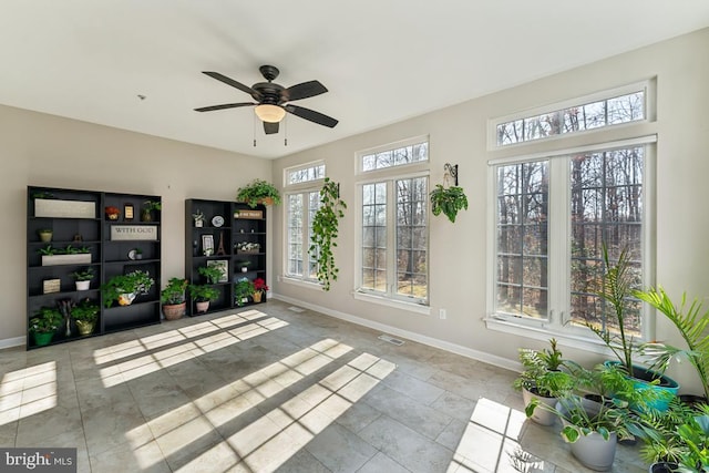 unfurnished sunroom with ceiling fan