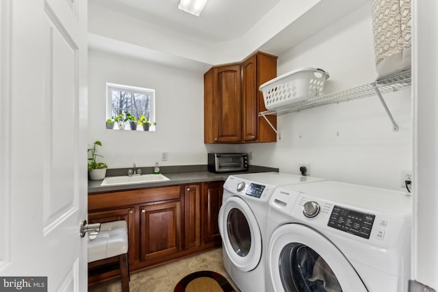 laundry area featuring sink, washer and clothes dryer, and cabinets