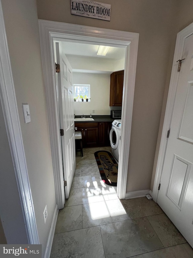 washroom featuring cabinets, sink, and washer / clothes dryer