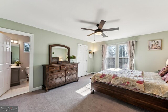 carpeted bedroom with ceiling fan and ensuite bath