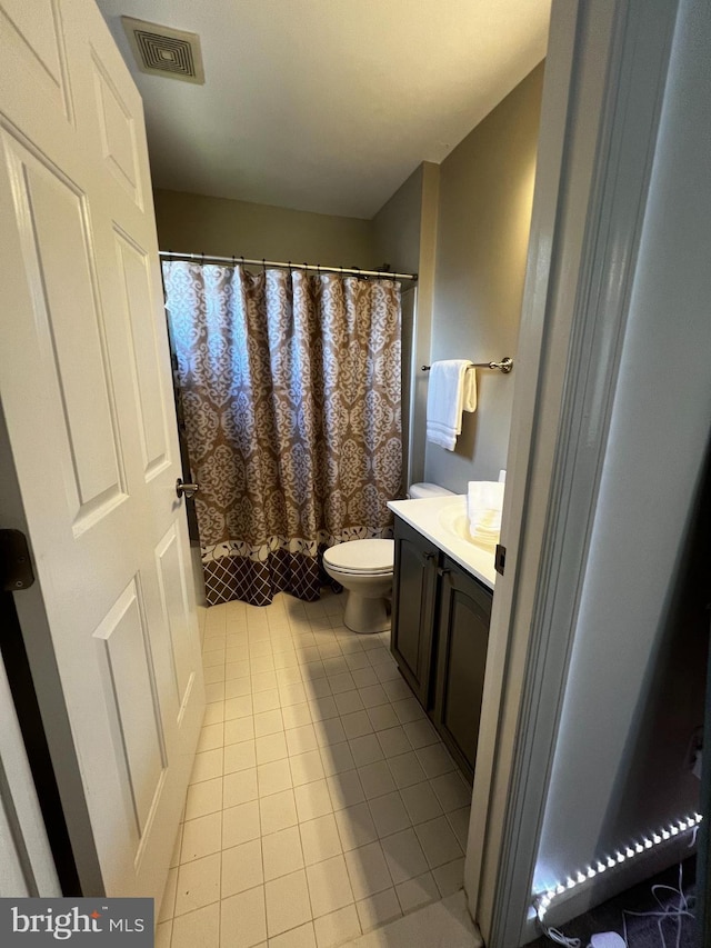 bathroom featuring a shower with shower curtain, vanity, toilet, and tile patterned flooring