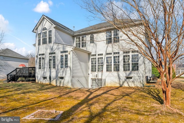 back of property with a deck and a lawn