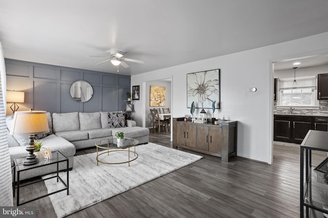 living room featuring dark hardwood / wood-style flooring and ceiling fan