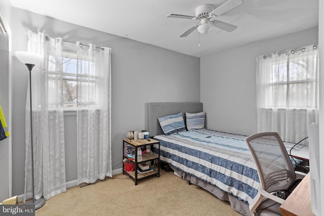 bedroom with multiple windows, carpet, and ceiling fan